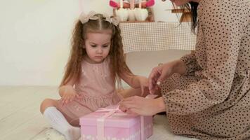 filha abre uma caixa com uma presente a partir de dela mãe em dela aniversário. video