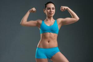 young athletic girl shows muscles photo