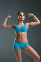 young athletic girl shows muscles photo