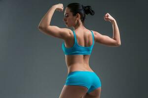 young athletic girl shows muscles photo