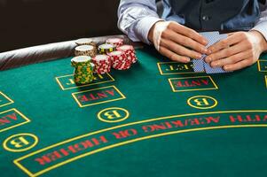 Closeup of poker player with playing cards and chips photo