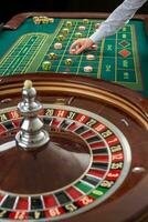 Roulette and piles of gambling chips on a green table. photo