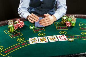 Closeup of poker player with playing cards and chips photo