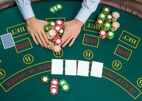 Closeup of poker player with playing cards and chips photo