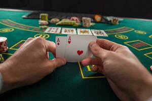 Male poker player lifting the corners of two cards aces photo