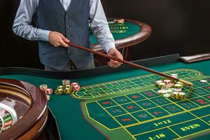 Roulette and piles of gambling chips on a green table. photo