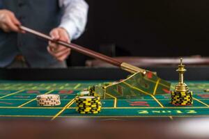 Croupier collects chips using stick in casino. photo