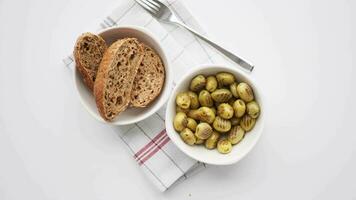 Turco grigliato olive nel un' ciotola e pane su tavolo stoffa video