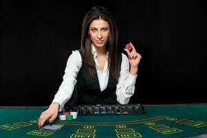 The beautiful girl, dealer, behind a table for poker photo