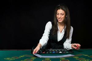 The beautiful girl, dealer, behind a table for poker photo