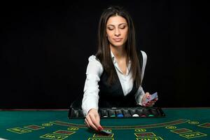 The beautiful girl, dealer, behind a table for poker photo