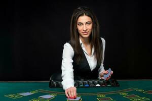 The beautiful girl, dealer, behind a table for poker photo