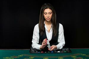 The beautiful girl, dealer, behind a table for poker photo