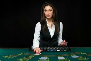 The beautiful girl, dealer, behind a table for poker photo