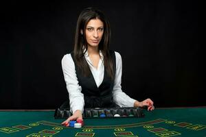 The beautiful girl, dealer, behind a table for poker photo