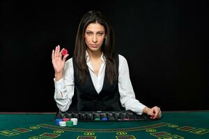 The beautiful girl, dealer, behind a table for poker photo