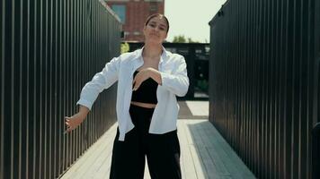 A girl in black and white clothes dances on the street. Contrast. video
