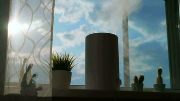 A working humidifier stands on the window while sunlight shines on it. video