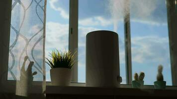 A working humidifier stands on the window while sunlight shines on it. video