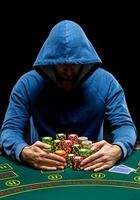 Poker player taking poker chips after winning photo