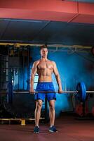 young man doing exercises with barbell photo