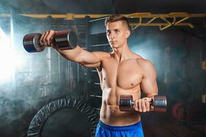 Man doing heavy weight exercise with dumbbells in gym photo
