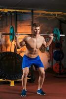 young man doing exercises with barbell photo