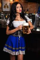 joven sexy Oktoberfest camarera, vistiendo un tradicional bávaro vestido, servicio grande cerveza jarra foto