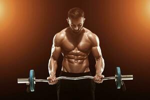 muscular man lifting weights over dark background photo