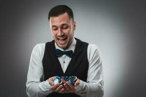 Poker player taking poker chips after winning photo