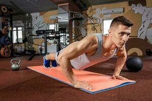 Young man doing exercises in the gym photo