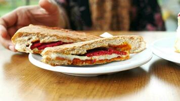 women hand pick Sandwich with ham, cheese, tomatoes,, video