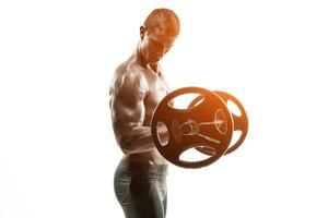 Strong man exercising fitness body building exercises with a barbell photo