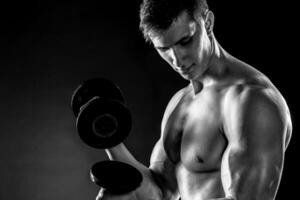 Mighty fitness man showing his gread body with dumbbells photo