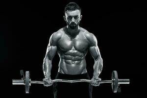 muscular man lifting weights over dark background photo