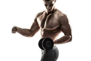 Athletic man showing muscular body and doing exercises with dumbbells photo