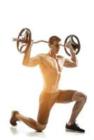 Mighty man standing on knee and holding barbell photo