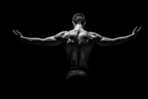 Rear view of muscular man with his arms stretched out photo