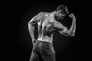 Healthy muscular man on showing perfect biceps, triceps, rear vi photo