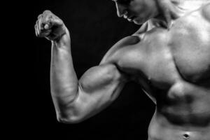 de cerca de hombre flexionando demostración su tríceps, bíceps músculos foto