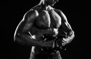 Mighty fitness man showing his gread body with dumbbells photo