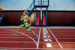 A female athlete runs along the treadmill. Sport background photo