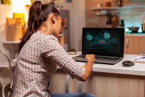 Angry hacker woman because of access denied while trying to attack government firewall. Programmer writing a dangerous malware for cyber attacks using performance laptop during midnight. photo