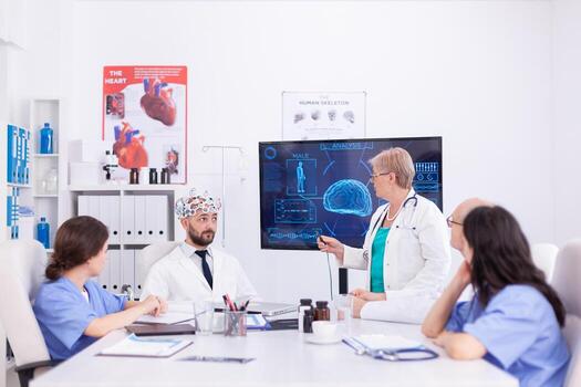 Consciousness doctor wearing headset with sensors for brain waves during neuoroscience, Monitor shows modern brain study while team of scientist adjusts the device. photo