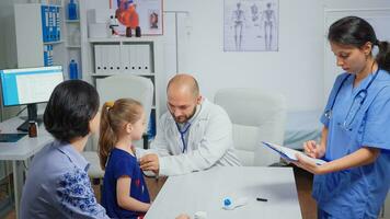 Doctor checking evolution of flu using stethoscope. Healthcare practitioner physician specialist in medicine providing health care services radiographic treatment examination in hospital cabinet photo