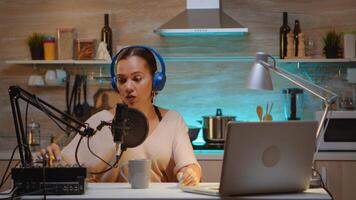 Talking on professional microphone during vlog recording in kitchen. Onair online production internet broadcast show host streaming live content, recording digital social media communication photo