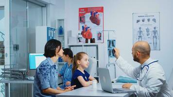 Doctor and patients looking at xray sitting in medical office. Physician specialist in medicine providing health care services consultation, radiographic treatment in clinic hospital cabinet photo