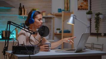 Vlogger speaking with follower on live using professional microphone wearing headphones. Creative online show Onair production internet broadcast host streaming live content, recording digital social media communication photo