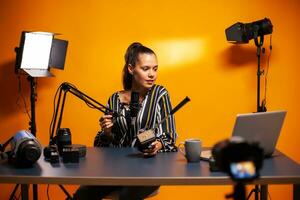 mujer camarógrafo participación fluido cabeza plato mientras grabación testimonial. social medios de comunicación estrella haciendo en línea Internet contenido acerca de vídeo equipo para web suscriptores y distribución, película foto