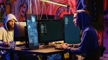 Asian hacker arriving in graffiti painted underground bunker, starting work on stealing valuable data using phishing technique. Cybercriminal tricking users into revealing sensitive information photo